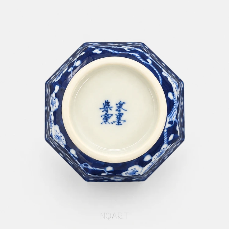 Set in two short columns, four characters sit under the glaze, with the plum tree still climbing the outside.