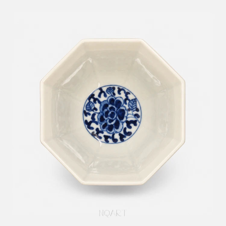 The well of the cup holds a single blue flower inside a drawn circle, and every other face is left bare.