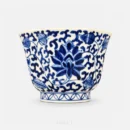 Between the rim and the foot, a scrolling lotus vine wraps all eight panels of this cup, with the largest bloom opening across the centre.