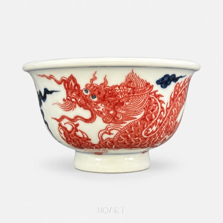 A five-clawed dragon in underglaze red sweeps across the body of this Ya Shou cup, its head thrown back mid-turn through cobalt clouds.