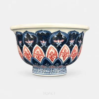 From this angle, the banded border at the shoulder sits directly above a run of pointed petals in underglaze red.