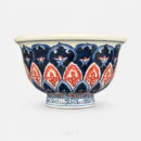 Beneath the rim line, three bands of lotus petals stack down the body of this Ya Shou cup, the middle one picked out in underglaze red.