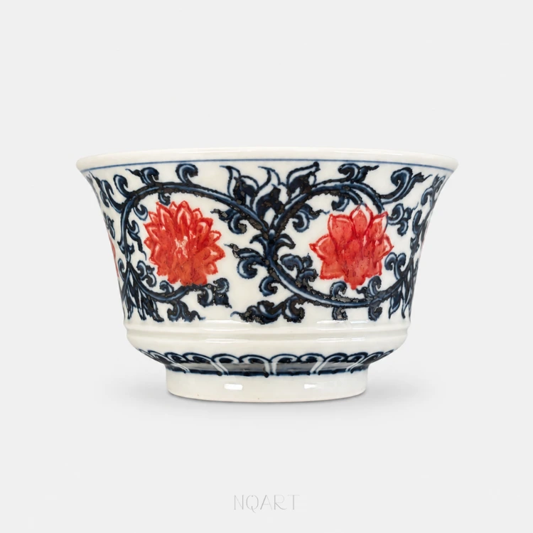 The lotus vine runs unbroken around this horse hoof cup, carrying two blooms in underglaze red through a dense mass of cobalt blue scroll.