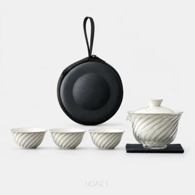 Five pieces on plain white: a camping tea set — three white cups in a row, the glass pitcher with its porcelain lid on top, a black tea cloth, and the round case standing behind them.