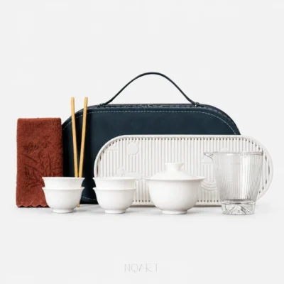 The whole set on a plain background: a complete travel tea set with tray — gaiwan, four tea cups, a glass pitcher, a slotted porcelain tea tray, a tea towel and bamboo tea chopsticks, with the navy case behind them.