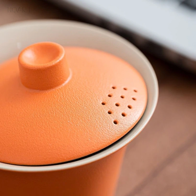 Close in on the lid of the gaiwan tea set — ten small holes punched in a grid, set into a fine-grained matt glaze.