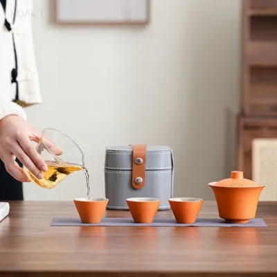 The whole gongfu tea set with case laid out along the cloth — three cups on the left, the case standing upright in the middle, the gaiwan at the far end.