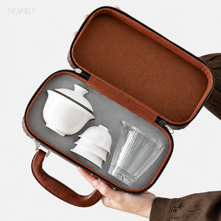 With the portable tea set with case open, the inside shows grey velvet and a recess shaped for the gaiwan, the cups and the pitcher.