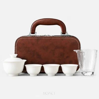 A six-piece portable tea set with carrying case, laid out in a row: porcelain gaiwan, three tea cups and a glass fairness pitcher, with the brown case standing behind them.