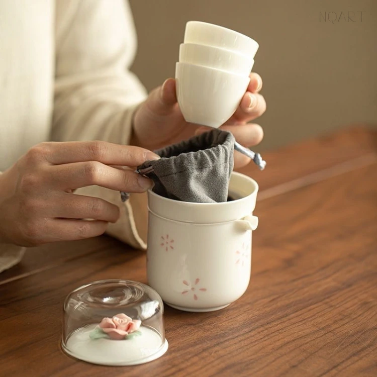 Lifted in one hand, the stackable tea cups come out of the case together while the other hand tucks the grey cloth pouch down into the brewing cup.