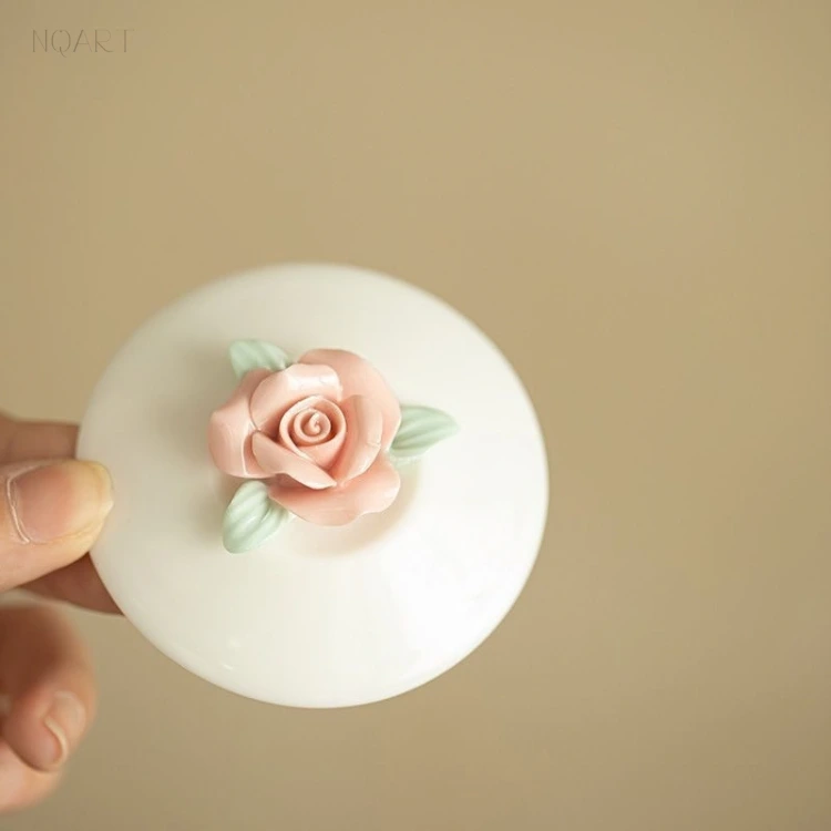 For a tea ceremony gift, the ornament is the point: a rose modelled in the round with pale green leaves, set on the flat of the lid.