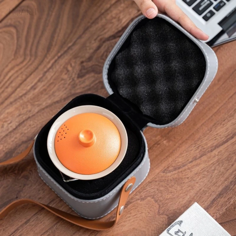 Opened up, the tea set with carrying bag shows a black moulded lining, with the orange gaiwan sitting in a recess of its own.