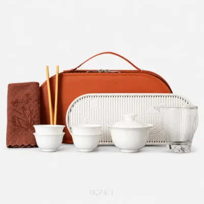 In orange this time, the tea set with travel bag sits behind the same white porcelain pieces, from the gaiwan through to the glass pitcher.