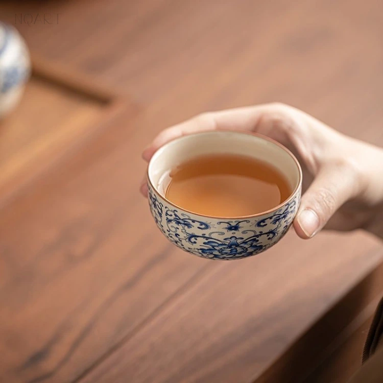Held level, one of the blue and white tea cups shows a full ring of scroll on the outside and nothing at all on the inside.