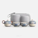Laid out straight, against white: a blue and white tea set — a teapot with a wood handle and spout, two matching cups, a lidded caddy, and the grey hard case standing behind them.