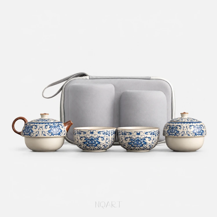 Laid out straight, against white: a blue and white tea set — a teapot with a wood handle and spout, two matching cups, a lidded caddy, and the grey hard case standing behind them.