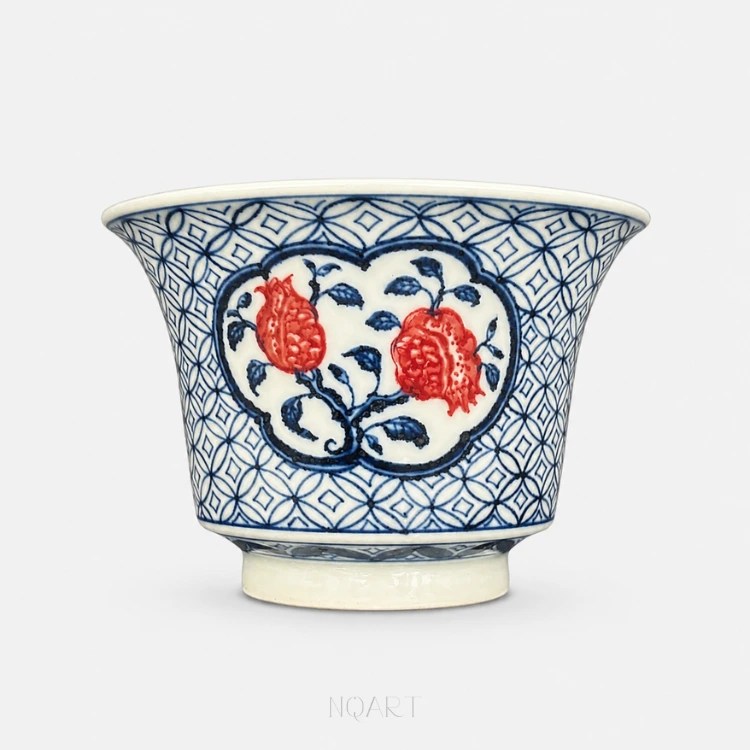 The ground stops at a heavy blue outline and leaves a white panel in the shape of a ruyi head, with two pomegranates and their branch inside it.
