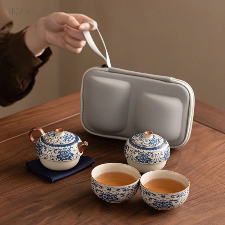 In the order they get used, this ceramic tea set sits on the table: pot, two cups, caddy, with the case hung open behind it.