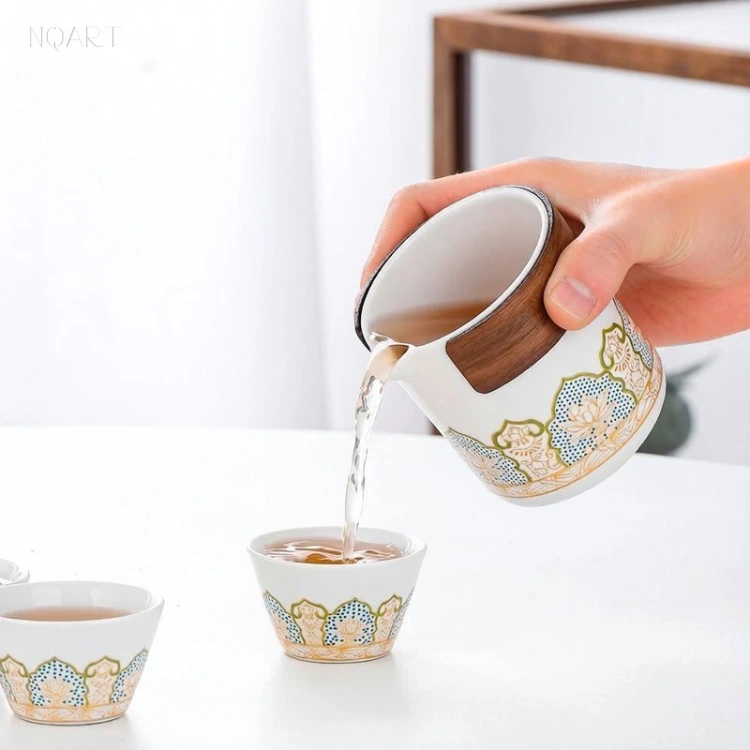 Pouring low over the table, the tea brewing cup fills the cups in turn, with the band of wood sitting above the pattern.