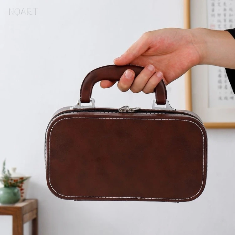Taken off the table by its handle, this tea set for camping travels as one closed block — case, clasp, and nothing loose.
