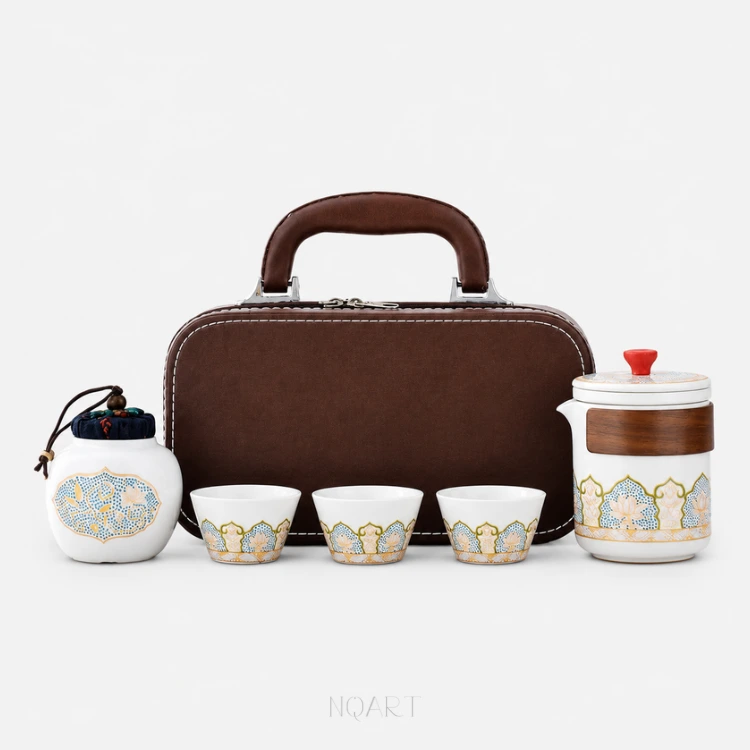 For the product shot, the whole set on white: a tea set with tea caddy — three cups and a brewing cup banded in gold-outlined arches, a lidded tea jar, and the brown case standing behind them.