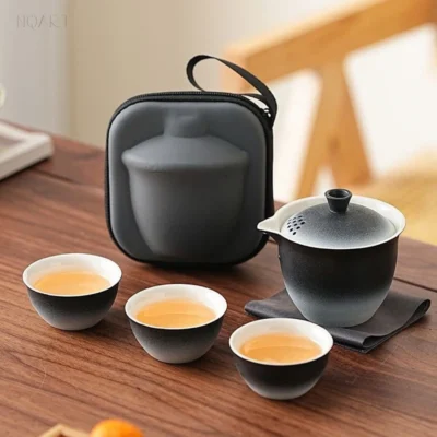 Across the wooden table, this two-tone tea set shows the fade the whole way through — gaiwan, three cups and the case standing behind.